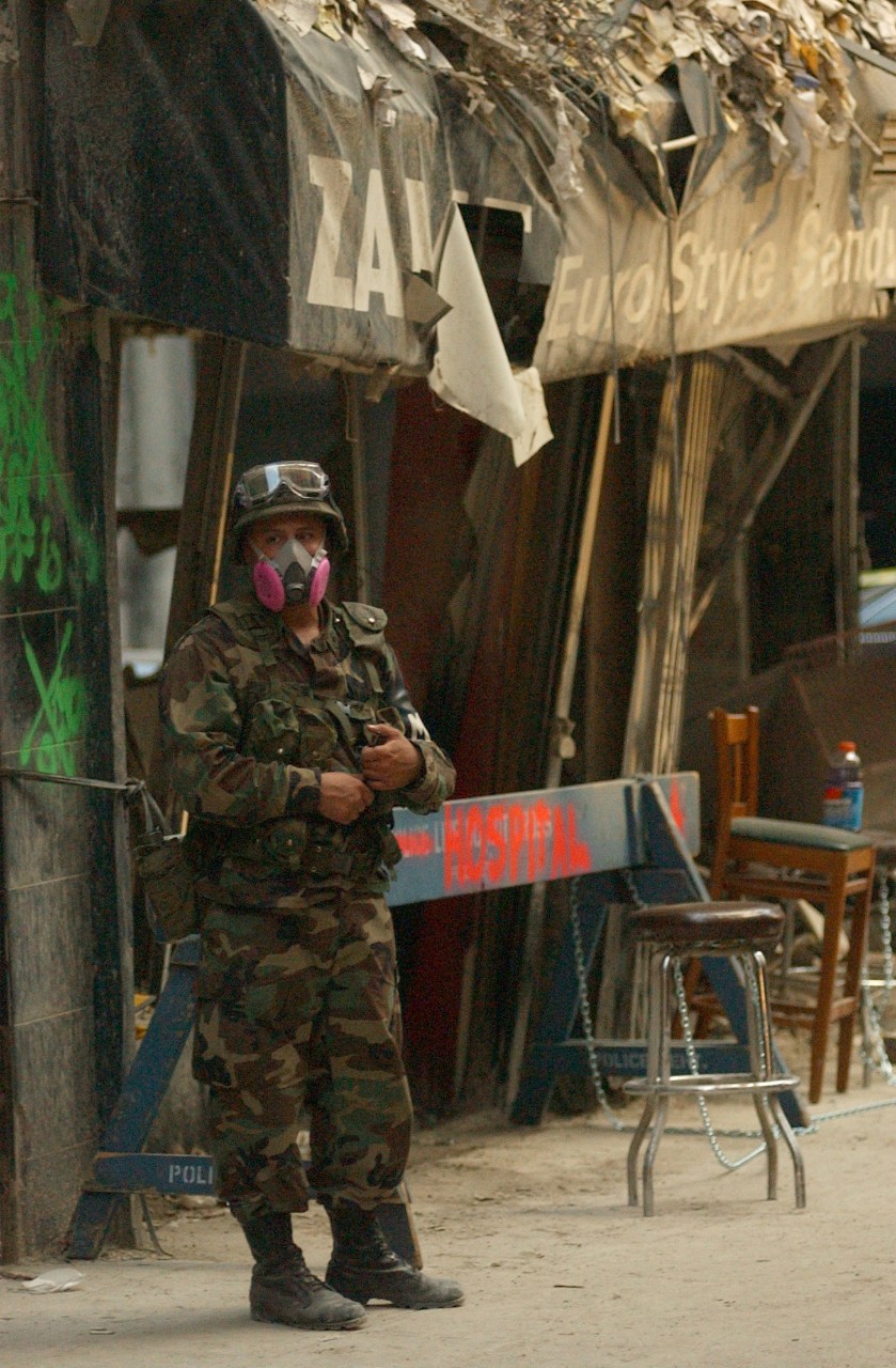 <p>An Army National Guard specialist works to prevent looting of buildings destroyed by the collapse of the World Trade Center, 16 September 2001</p>