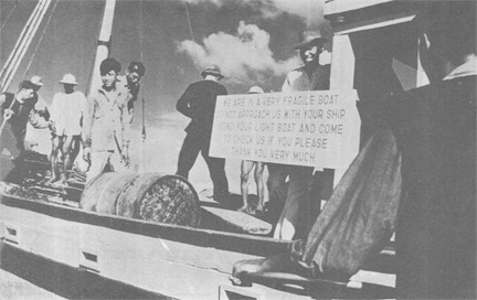 Image of A Sign Provides a Brief Moment of Humor as USS LOYALTY (MSO 457) Crewmen Prepare to Board a Vietnamese Junk during Visit and Search Operations