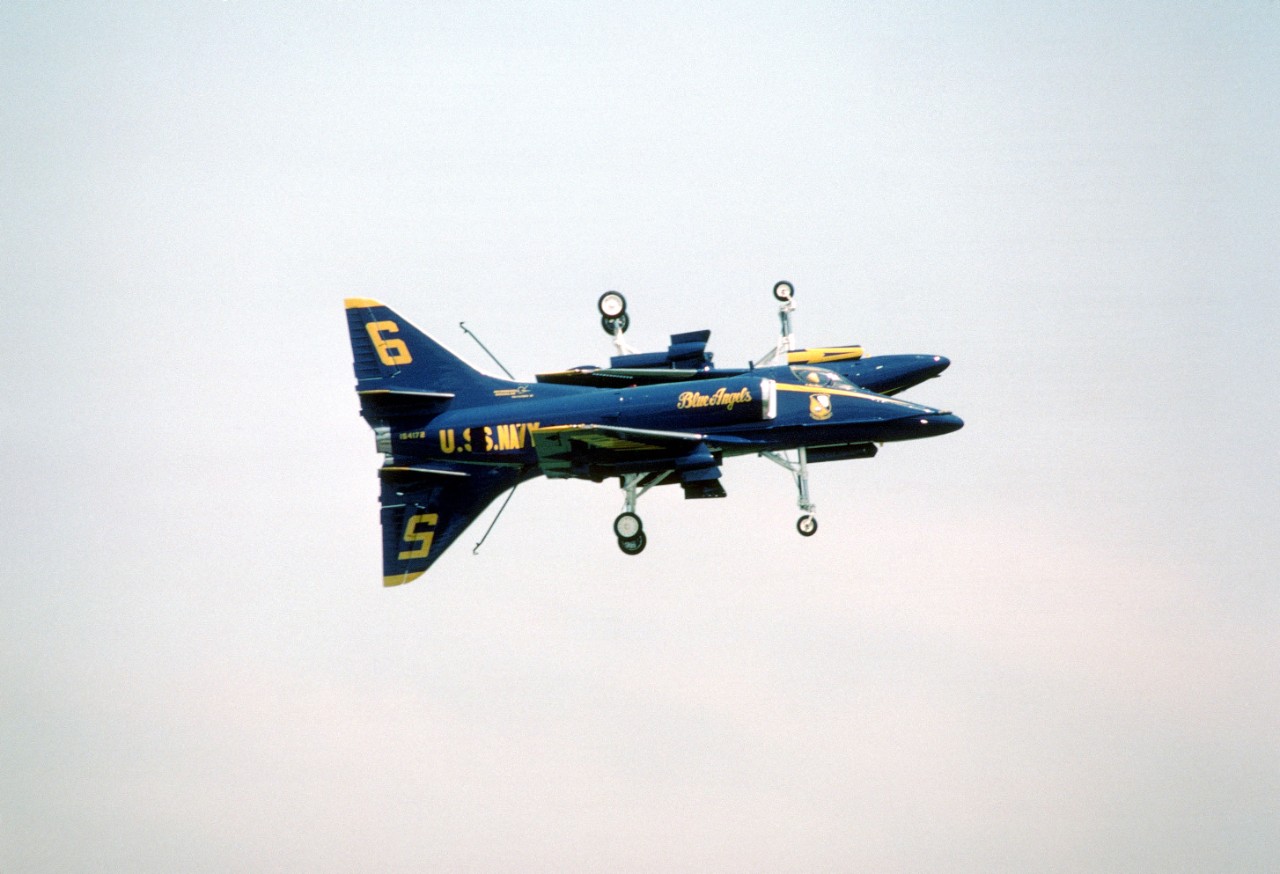 330-CFD-DN-SC-85-00445:  Blue Angels Maneuver:  Fortus.   A-4F Skyhawks, September 1984.   Two Blue Angels execute the Fortus maneuver during an air show.  In this wingtip-to-wingtip maneuver, both aircraft have their landing gear and tail hooks lowered and one aircraft is inverted.   Photographed September 9, 1984.  Official U.S. Navy photograph, now in the collections of the National Archives. 