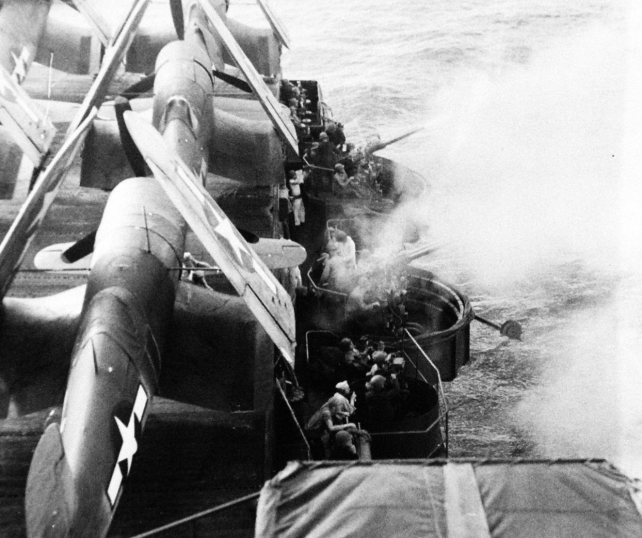 80-G-218364:  Vought F4U Corsair, February 1944.  Starboard battery on board USS Gambier Bay (CVE-73) in action during Marshall Islands Campaign, February 15, 1944.   Note the 40 mm, and the F4U’s with folded wings on flight deck. Official U.S. Navy Photograph, now in the collections of the National Archives.  