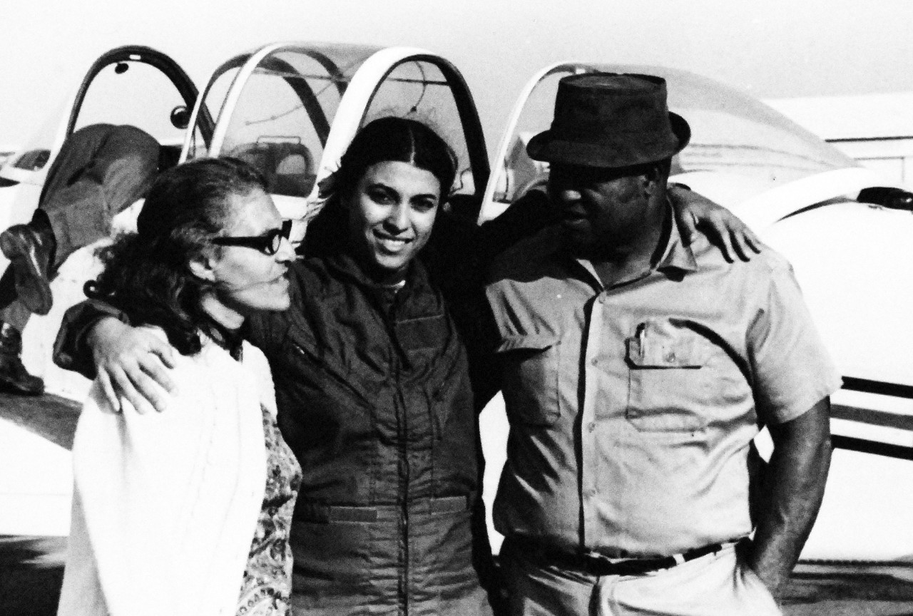 428-GX-USN-1160766: Navy Aviation Officer Candidate Jill Brown, 1974.  Hyattsville, Maryland.  Aviation Officer Candidate Jill Brown and her parents, Mr. and Mrs. Gilbert Brown stand alongside a T-34B Mentor training aircraft.  Twenty-four-year-old Miss Brown was the first African-American to qualify for training as a military pilot.  Photographed by PHC James E. Markham, received January 1975.  Official U.S. Navy Photograph, now in the collections of the National Archives.  