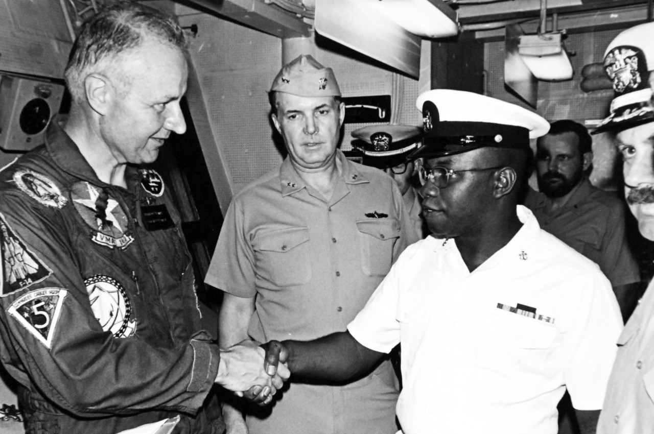 428-GX-USN-1166412:   Chief Machinst’s Mate Joseph Moore, 1975.  Secretary of the Navy J. William Middenforf, II, congratulates Chief Machinist’s Mate Joseph Moore after giving him the reenlistment oath onboard USS Fanning (FF-1076).  Photographed by PH1 John R. Sheppard, December 12, 1975.  Official U.S. Navy Photograph, now in the collections of the National Archives.  