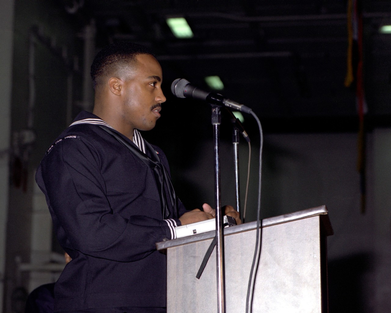330-CFD-DN-SC-86-10322:   Black History Week, February 1986.   A U.S. Navy Sailor addressed crew members and guests during a Black History Week celebration onboard USS Carl Vinson (CVN-70).   Photographed by PH2 C.F. Laws, February 20, 1986.   Official U.S. Navy Photograph, now in the collections of the National Archives.   