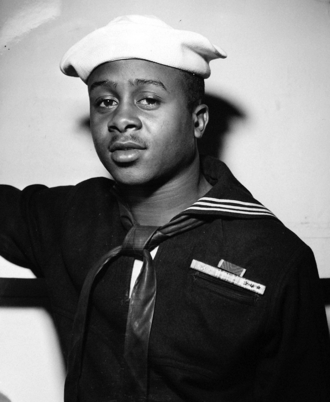 208-NP-8FF-1:  Steward's Mate Eli Benjamin, 1944.    African-American gunner, who stayed at his gun until a Japanese plane crashed into the gun position, was presented the Bronze Star medal at ceremonies on board USS Intrepid (CV-11).  At the direction of Vice Admiral Marc A. Mitscher, the award was presented to Steward’s Mate Eli Benjamin, who was cited for “extraordinary heroism.”  Benjamin and five other African-American steward’s mates had volunteered to man a 20mm gun board the carrier.  When under attack, Benjamin and his mates continued firing their gun at a flaming Japanese aircraft, even when it was apparent the plane was going to fall in their gun position.  “The courage and skill he displayed were at all times in keeping with the highest traditions of the Naval Service,” Vice Admiral Mitscher said.   Official Office of War Information photograph, now in the collections of the National Archives.  