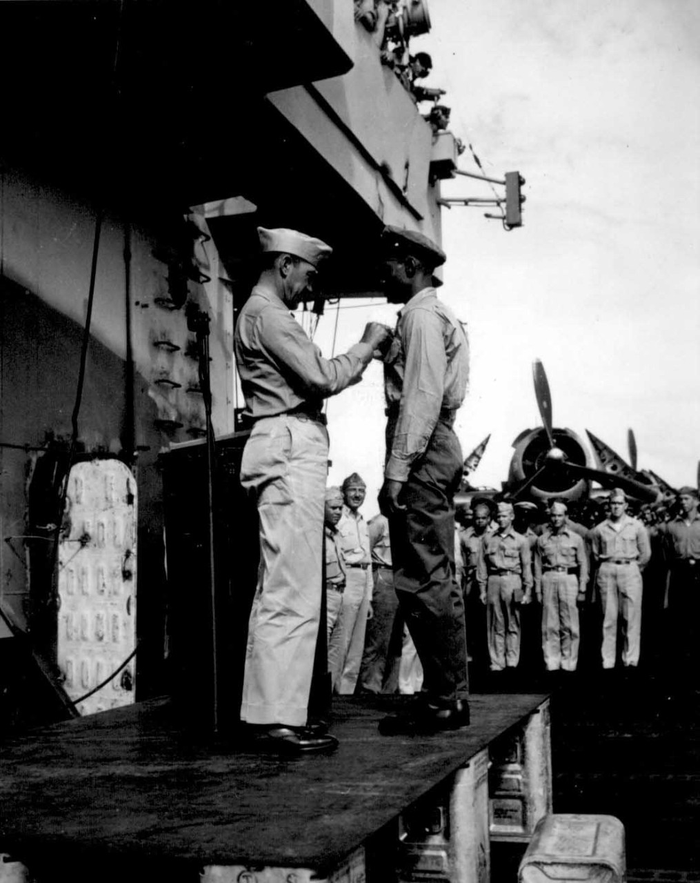 80-G-291220:  Steward's Mate Third Class Fred Magee, Jr., October 1944. Capt. H. W. Taylor making award presentations aboard USS. Cowpens (CVL-25). Fred Magee, Jr., St3/c USN, receiving commendation of the Secretary of the Navy." The commendation was for attempting to rescue, at a risk to his own life, a shipmate from drowning, October 1944.    Official U.S. Navy photograph, now in the collections of the National Archives.   