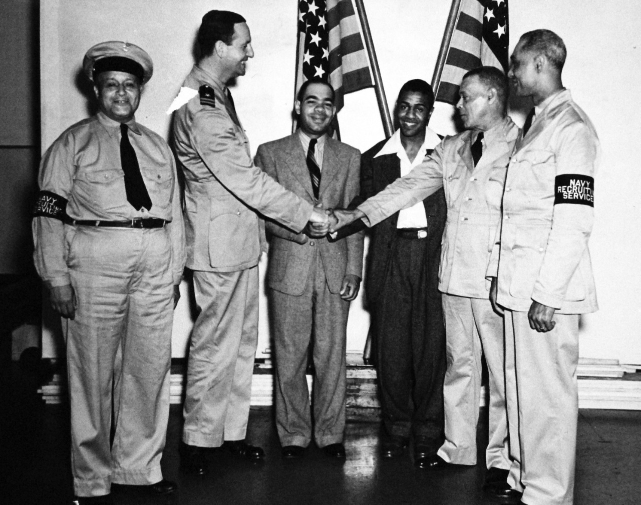 80-CF-882-3_Box 175:   African Americans sworn in for duty, June 1942.   Shown, left to right:  Chief Gunner William H. Brady, Lieutenant Kenneth B. Emmons, Henry Fortune, James T. Howard, Jr., Chief Walter Tender Joseph Brinkley and Chief Recruiting Specialist Earl Ross, at Philadelphia, Pennsylvania, June 1942.  Official U.S. Navy photograph, now in the collections of the National Archives.