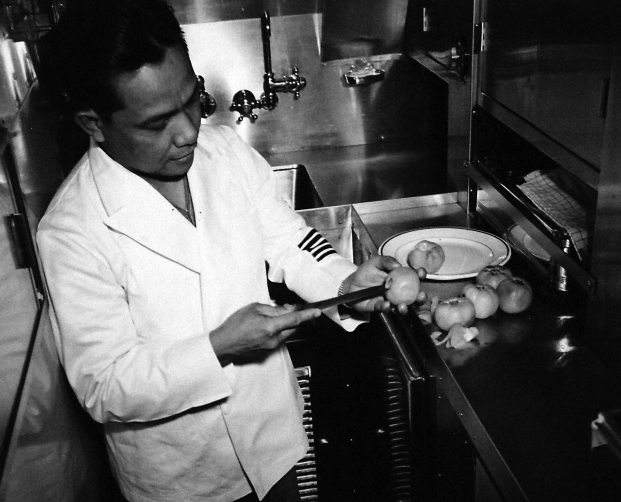 80-G-41801:   Life aboard a U.S. submarine, 1943.    In the wardroom kitchen, an officer’s steward fixes tomatoes for a salad.     Photographed June 8, 1943.  Official U.S. Navy Photograph, now in the collections of the National Archives.  