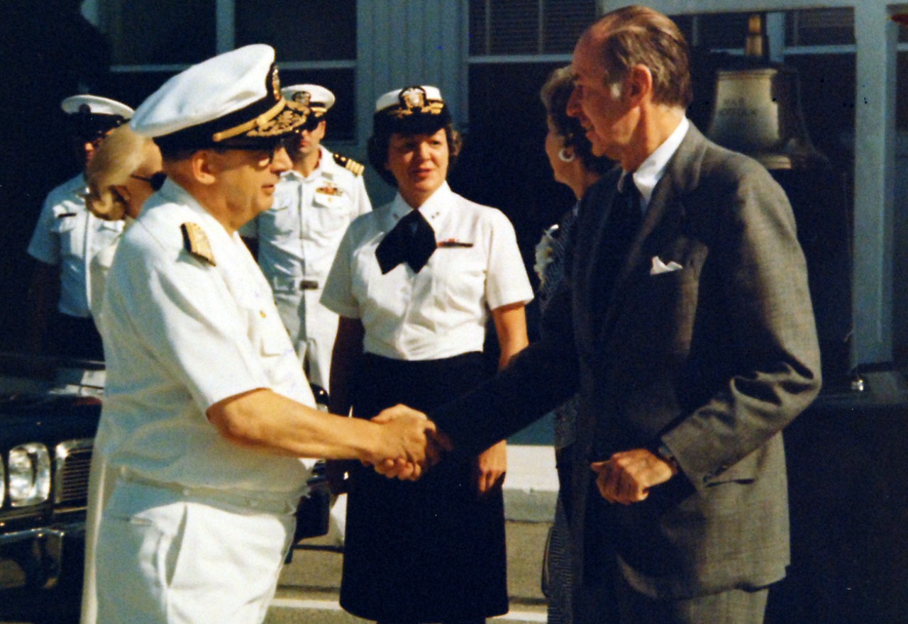 428-GX-KN-25827:  Rear Admiral Frank McKee, May 1977.   Admiral Isaac C. Kidd, Jr., (left), shakes hands with Secretary of the Navy W. Graham Claytor, Jr., as Claytor prepares to depart after a tour of the Norfolk, Virginia, area.  Mrs. Kidd, Rear Admiral Fran McKee, Director of the Naval Educational Development on the staff of the Chief of Naval Education and Training and Mrs. Claytor stand behind.   Photographed by PH1 Don Deverman, May 28, 1977.   Official U.S. Navy photograph, now in the collections of the National Archives.   