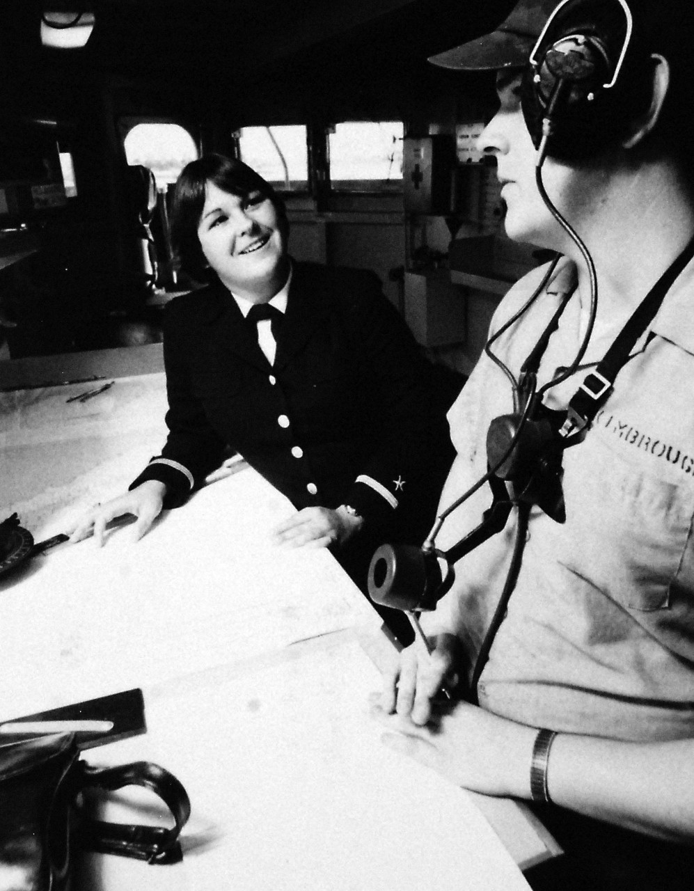 428-GX-USN 1173348:  Ensign Roberta McIntyre, October 1978.   McIntyre chats with a crewman on the bridge of USS Dixon (AS-37) during a tour of the ship at San Diego, California, where she is assigned as Assistant Navigator.  She is one of the first group of women officers to serve onboard U.S. Navy ships.  Photographed by PH2 J. Brown, October 31, 1978.  Official U.S. Navy Photograph, now in the collections of the National Archives. 