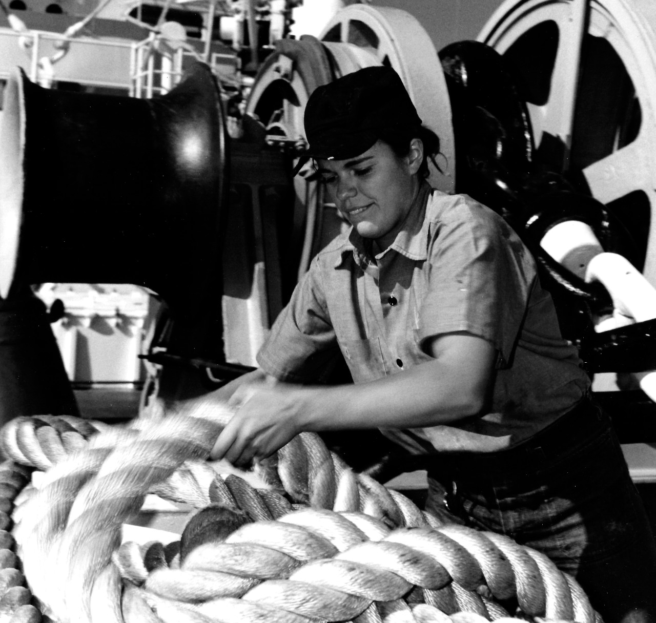 KN-21394:   Seaman Anneliese Knapp, February 1974.   Seaman Knapp unravels line from a bitt aboard the hospital ship, USS Sanctuary (AH-17).   Photographed by PH3 L.D. Anderson.   Official U.S. Navy photograph, now in the collections of the National Archives.  Black and white image only.  