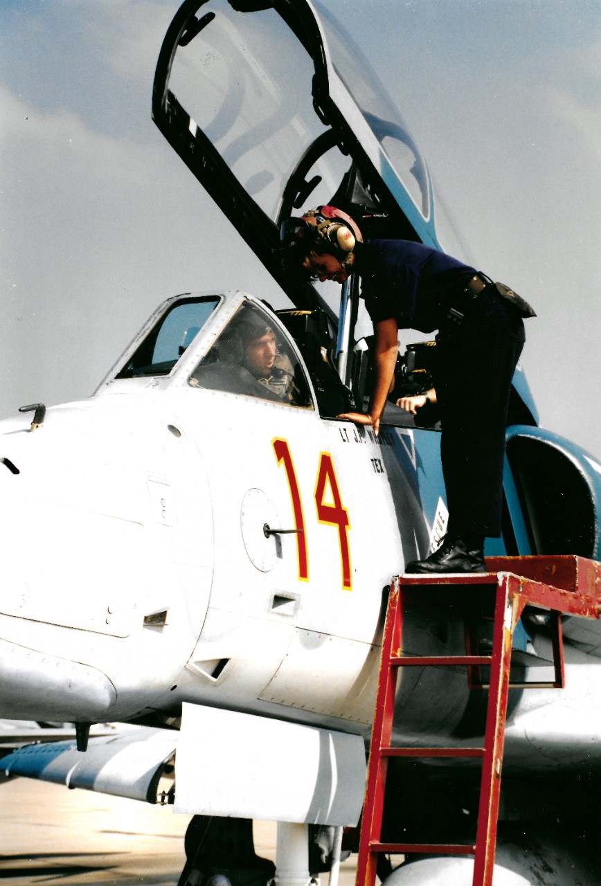 330-CFD-DN-SC-95-00027:   Airman Mary Garcia, November 1994.   Garcia, a plane captain for Fighter Squadron 126 (VF-126) performs preflight inspections with the pilot of a TA-4J Skyhawk aircraft.   Photographed by PH3 Jason Marzini, November 24, 1994.   Official U.S. Navy Photograph, now in the collections of the National Archives.  