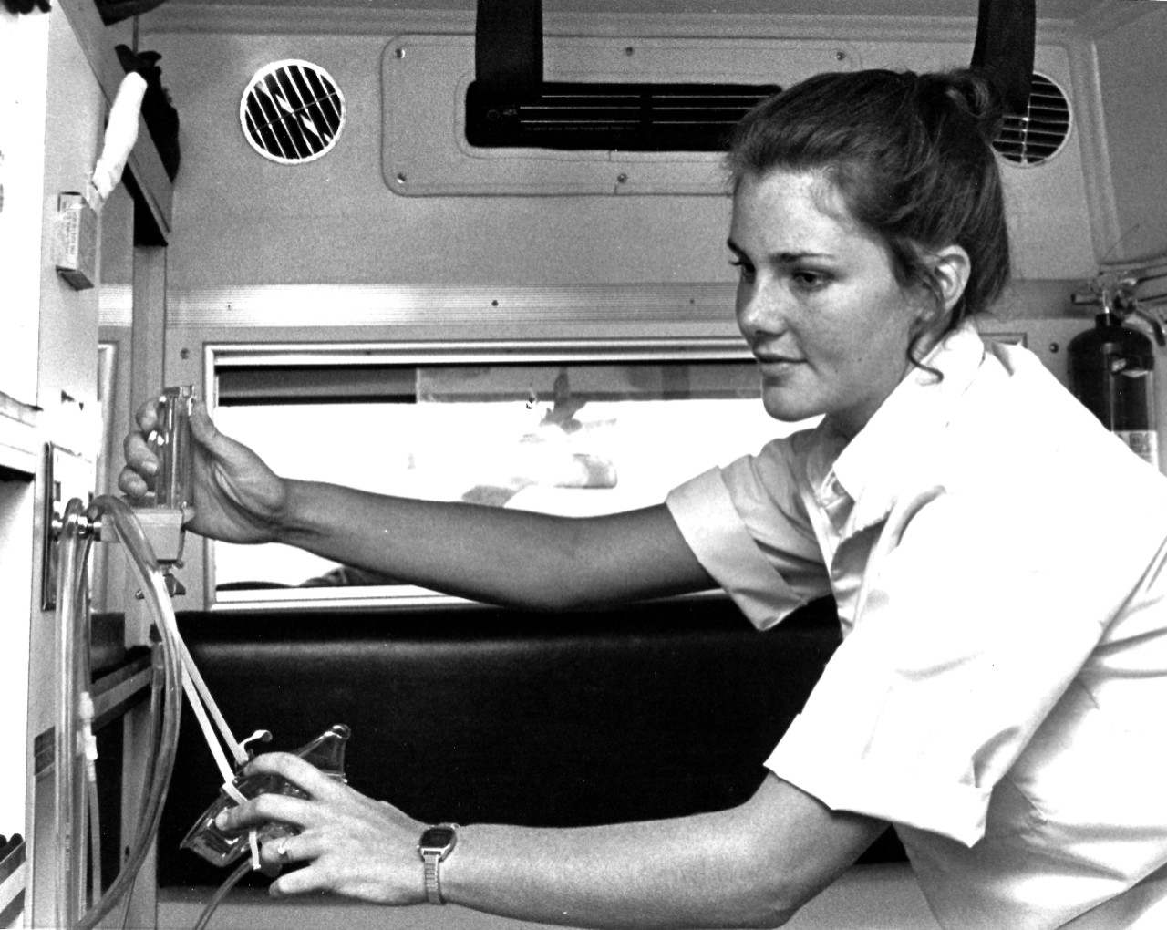 330-CFD-DN-SN-84-01318:   Petty Officer Second Class Kathleen Kerr, September 1982.   Kerr, a Hospital Corpsman, checks the oxygen system in one of the U.S. Naval Hospital ambulances, while standing duty as an Emergency Technician.   Photographed by JO1 Glenna Houston, September 1, 1982.   Official U.S. Navy photograph, now in the collections of the National Archives.  