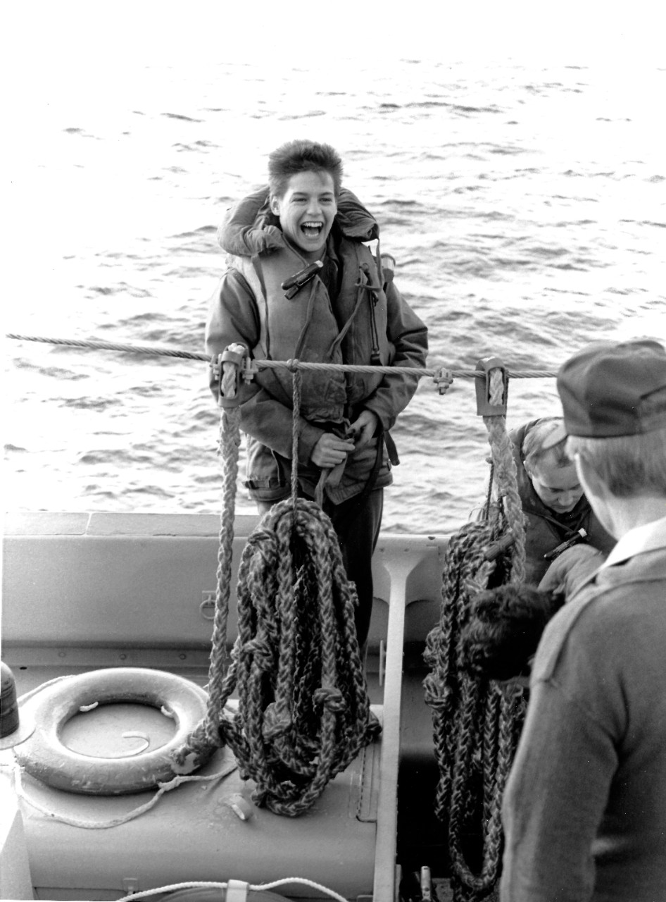 330-CFD-DN-SN-88-06109:   Engineman Third Class Ann Marie Daub, February 1988.   Daub stands in a motor whale boat while participating in a person-overboard drill.  Daub, one of two women comprising the seven-person boat crew, is assigned to the submarine tender, USS McKee (AS-41).  Approximately 350 women are currently part of the McKee’s 1,250 member crew.  Photographed by PHC Fraker, USN, (Retired).  Official U.S. Navy photograph, now in the collections of the National Archives.  