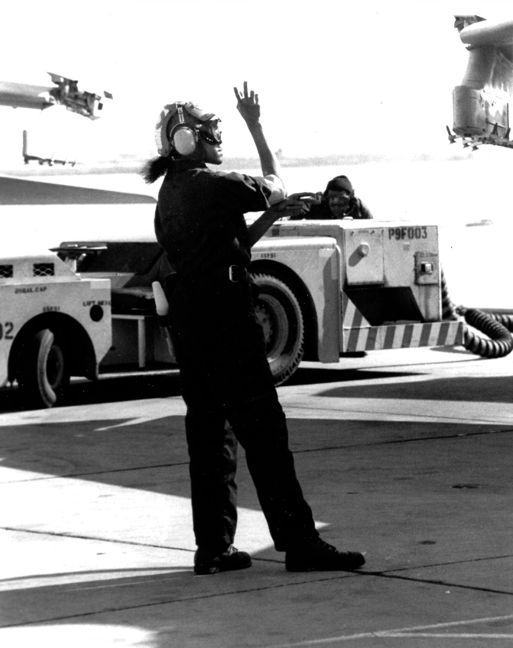 330-CFD-DN-SN-89-01686:   Airman Ora Howard, November 1988.   Howard, Plane Captain, signals instructions to the pilot of an A-7 Corsair II aircraft.  Photograph by JO3 Cyndi Reilly and received November 22, 1988.    Official U.S. Navy Photograph, now in the collections of the National Archives.