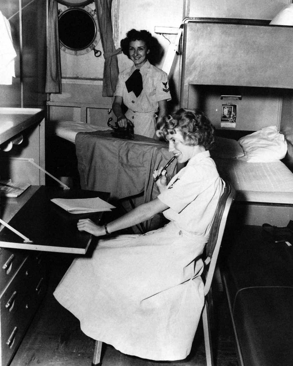 USN 709038:   Navy Accepts Women Volunteers for Duty on High Seas, October 1953.   Evenings and spare time isn’t always spent in recreation.  In their cabin on board USNS George M. Goethals (T-AP-182) , both WAVES have personal things to care for.  While Hospital Corpsman Third Class Maria A. Myers ponders over what to say in that special letter, Hospital Corpsman Second Class Eileen Paluzzi irons her smock.   For the first time in history, the U.S. Navy has accepted volunteers for duty on the high seas from women in the enlisted WAVES.  Those eligible were WAVES of the Hospital Corps to fill sixty-three billets on ships of the Military Sea Transportation Service.  Photograph released October 26, 1953.    Official U.S. Navy photograph, now in the collections of the National Archives.   