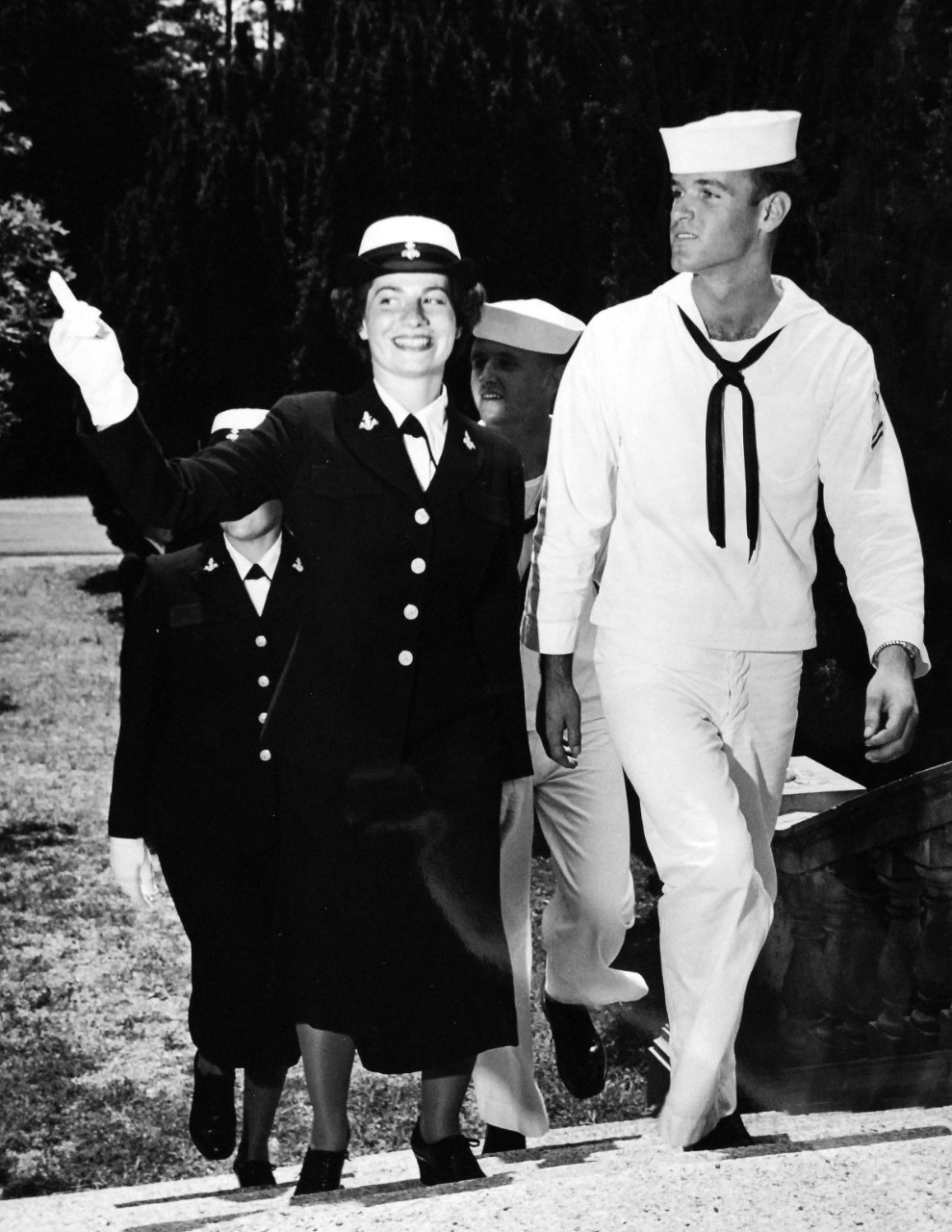 USN 709491:    WAVES Observe 13th Anniversary: Preparatory to their Thirteenth Anniversary, July 1955.   Seaman Apprentice WAVE and a male Seaman Apprentice enter the Old Jacob Tome School at Bainbridge, Maryland.   Master Caption:  WAVES Observe 13th Anniversary:   Preparatory to their Thirteenth Anniversary, July 30, WAVE Recruits at the Naval Training Center, Bainbridge, Maryland, pass in review.  These young women will take their places with sailors in important technical and clerical duty assignments both at home and abroad.  At that time, there were approximately 7,000 WAVES on active duty in the U.S. Navy.   Photograph released July 25, 1955.  Official U.S. Navy photograph, now in the collections of the National Archives.   
