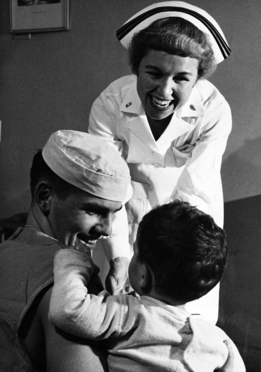 USN 709748:   U.S. Navy Nurse Lucille F. Neary, January 1957.  Navy Nurse Neary and Hospital Corpsman Third Class Paul J. Altman, Jr., enjoy their duties in a children’s ward at U.S. Naval Hospital, Bethesda, Maryland.   Photograph released January 4, 1957.   Official U.S. Navy photograph, now in the collections of the National Archives.   