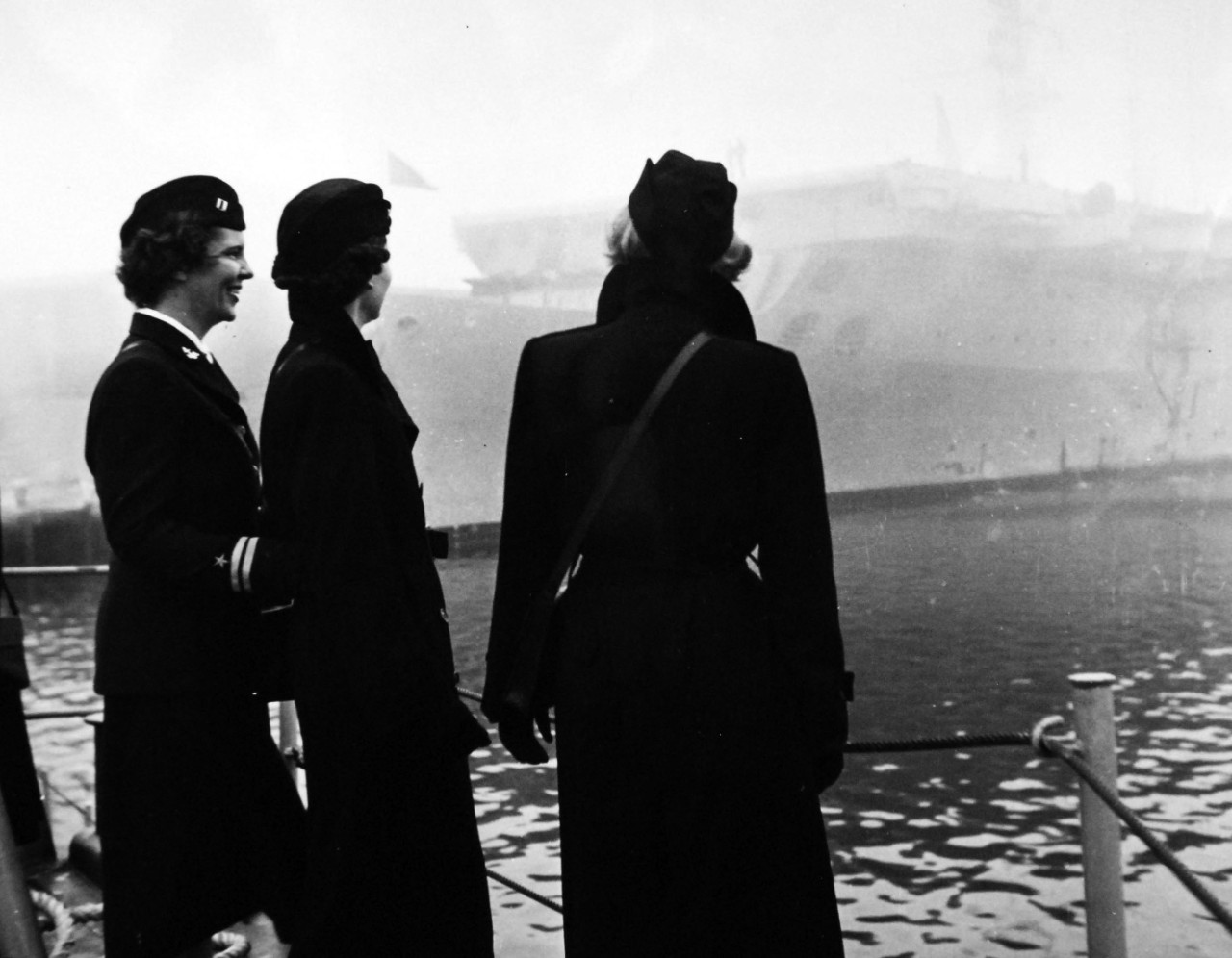 USN 708499:   “Return to Base”, January 1952.    WAVES back on board the LSI for their return trip to the Naval Training Base at Newport, Rhode Island, the WAVE officers had a clear picture of how the ships of the fleet operate while at sea.  Lieutenant Anne Ducey, Officer in Charge of the Visitors, and Ensigns Elizabeth A. Harris and Eva Schekorra watched the fog settle from their floating classrooms in the background.  The WAVES felt more fully prepared for future class studies after “joining” the Fleet.   Photograph released January 21, 1952.  Official U.S. Navy photograph, now in the collections of the National Archives.  