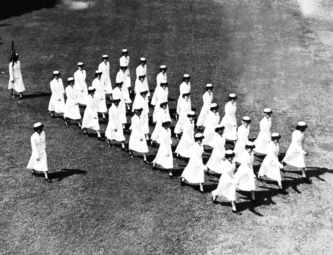 USN 708652:   Ten Years of the WAVY Blue, July 1952.   Drill Team.   The WAVES have been famous for their drill teams, one of which was recently featured in a movie.  The WAVE Drill Team of the Naval Training Center at Bainbridge, Maryland, sticks out as they begin one of the many formations executed by the 34 WAVE Trainees.  This drill formation, like the formations used going to classes, help the nautically minded women volunteers to better understand the necessity for a smart trim unit needed to win the competitive honors awarded WAVE companies going through their “Boot Camp.”  Photograph released July 24, 1952.  Official U.S. Navy photograph, now in the collections of the National Archives.  