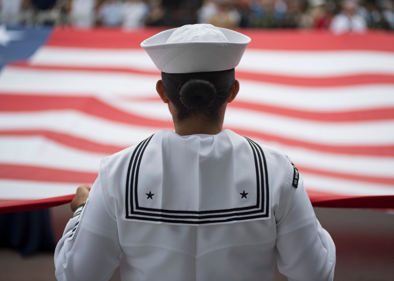 180528-N-UP035-0245:  A Sailor helps unfurl an American flag, 2018.    The unfurling was done during a Memorial Day ceremony at the Intrepid Sea, Air and Space Museum in New York City, New York, during Fleet Week New York 2018. Now in its 30th year, Fleet Week New York is the city's time-honored celebration of the sea services. It is an unparalleled opportunity for the citizens of New York and the surrounding tri-state area to meet Sailors, Marines and Coast Guardsmen, as well as witness firsthand the latest capabilities of today’s maritime services.   Photographed on May 28, 2018 by Mass Communication Specialist 1st Class Mike DiMestico.    Official U.S. Navy Photograph.  