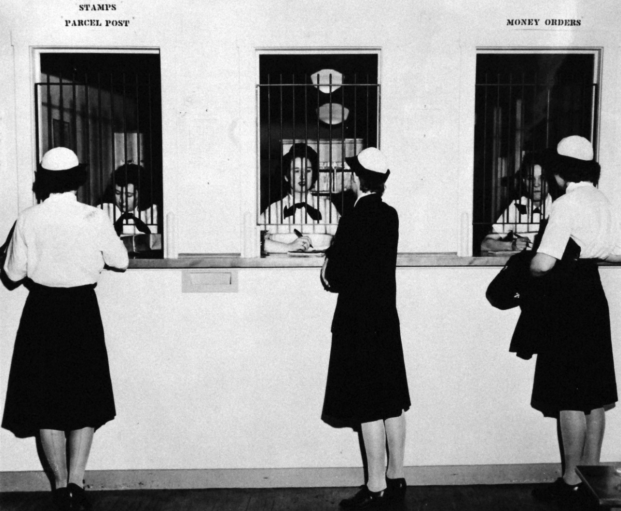 80-G-45722:   First Post Office of its size in U.S. History to be entirely staffed by women, June 1944.     Photographed at WAVES Quarters D, Washington, D.C.    Shown are three mail specialists on duty (left to right):   SP(N)3 Ruth Carter; SP(M)3 Patricia V. Campell, and SP(M)3 Marion C. Eastman, June 18, 1944.   Official U.S. Navy photograph, now in the collections of the National Archives. 