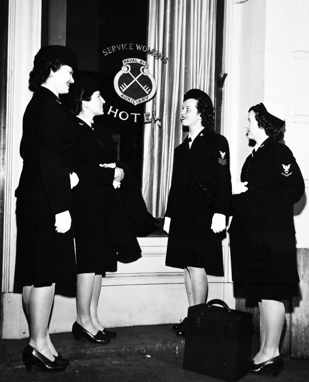 80-G-300971:  Service Dress Blue, January 1945.   Group of WAVES at new Naval Aid Auxiliary Hotel for Women at 20 Jones Street, San Francisco, California. Shown (left to right): SP2c Emily Browne; Y3c Jennie Dolish; Y1c Annette Smith; and Y3c Frankie Shropshire.  Photograph released January 29, 1945.  Official U.S. Navy photograph, now in the collections of the National Archives.  
