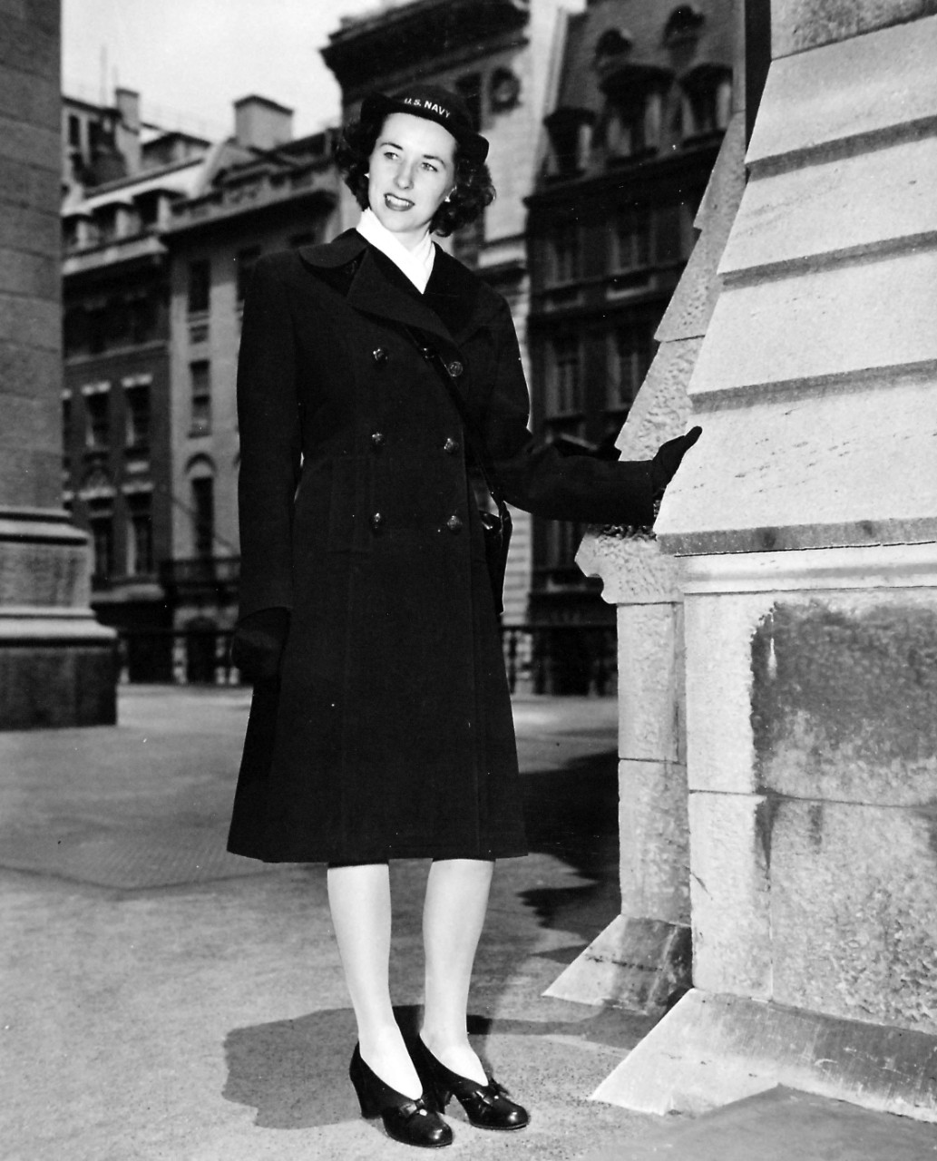 80-G-46611:  Overcoat (front), June 1944.  Correct uniforms worn by enlisted personnel of the Women’s Reserve, U.S. Naval Reserve, are modeled by Specialist (R)2c Jeanne Henry, attached to the Office of Naval Officer Procurement, in New York City.  This optional item as uniform is worn as an alternative to the raincoat in cold seasons.  The white muffler also is optional.  Released June 22, 1944.  Official U.S. Navy Photograph, now in the collections of the National Archives.  