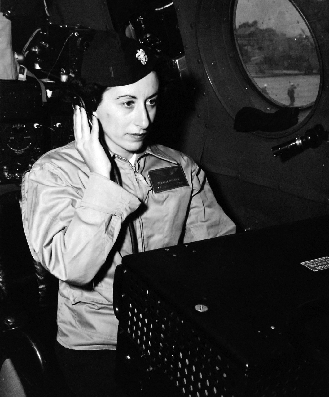 80-G-49789: Flight Jacket, April 1945.   WAVE Naval air navigator at her job at Naval Air Station, San Diego, California.   Lieutenant Junior Grade Celilia Heimlich, using equipment which enables an air navigator to obtain a “fix” through radio bearings while in flight.   Received April 7, 1945.   Official U.S. Navy photograph, now in the collections of the National Archives.  
