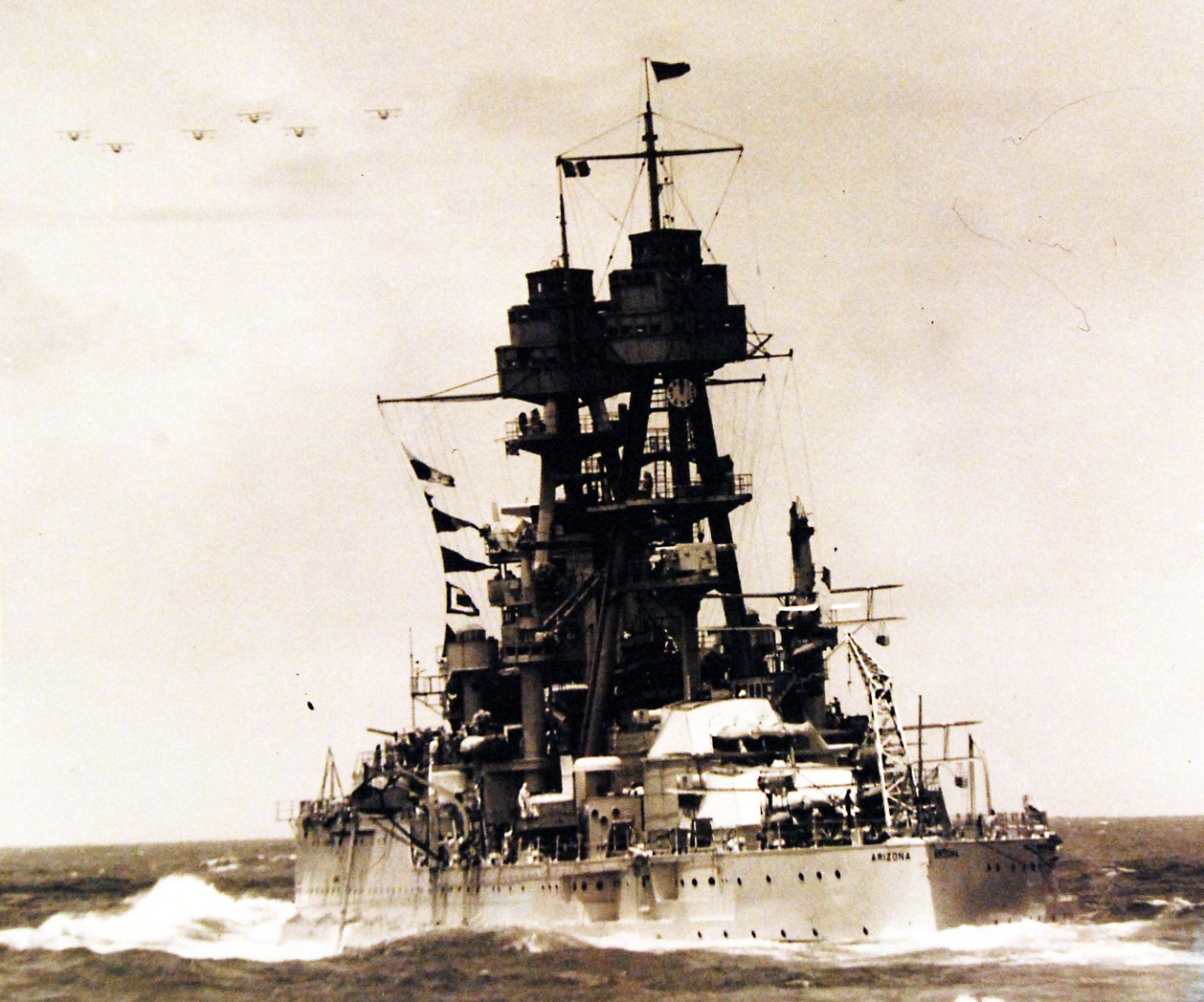 <p>80-G-1009378: USS Arizona (BB 39) shown beneath the welcoming planes. Hawaiian panes extend a welcome to the approaching fleet upon its completion of recent maneuvers and arrival in Hawaiian waters. Photograph received 1957.&nbsp;</p>

