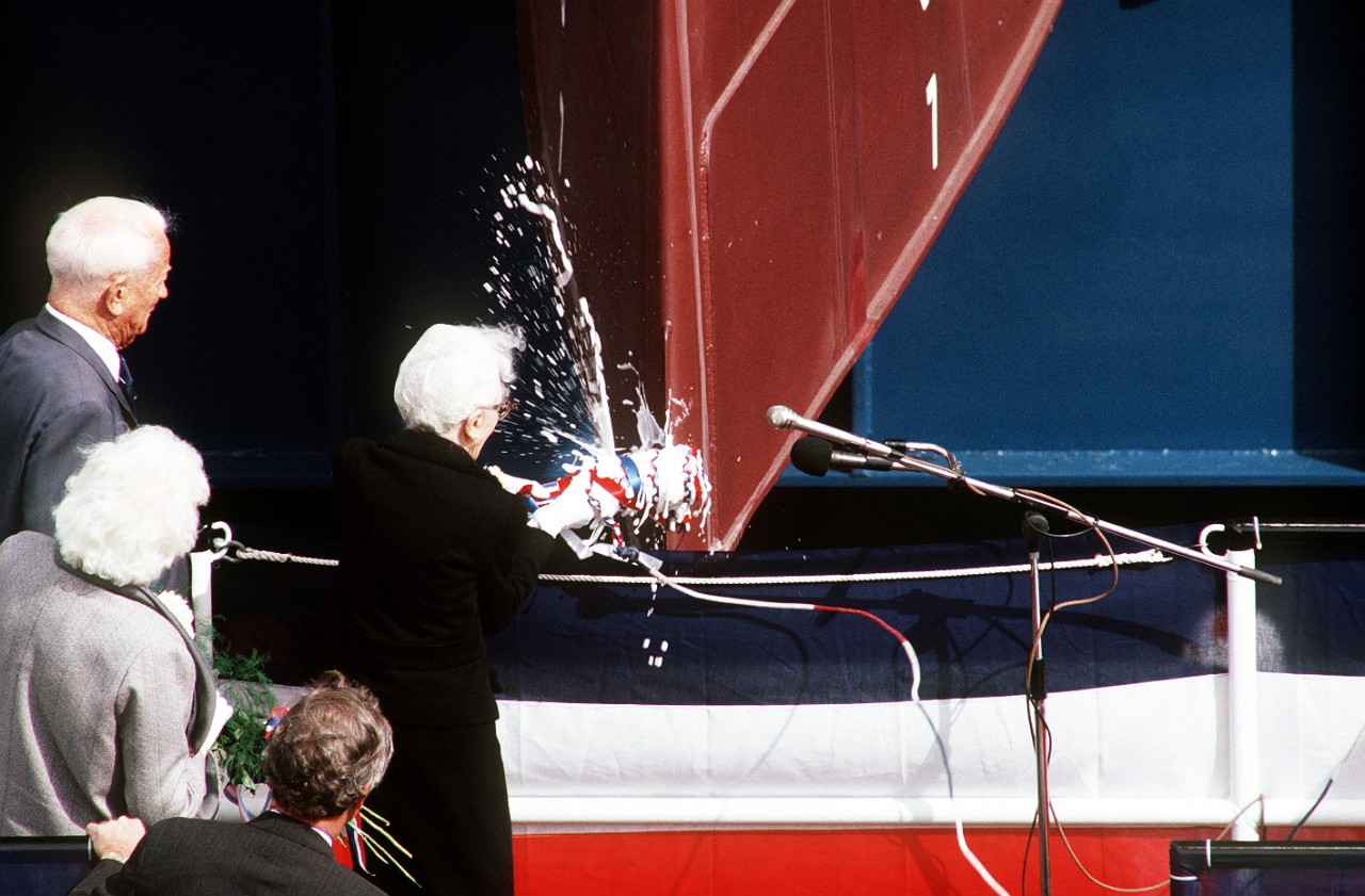 330-CFD-DN-ST-90-09192:   USS Arleigh Burke (DDG-51), 1989.   Roberta Burke, wife of Admiral Arleigh A. Burke, USN, (Retired), Sponsor of the guided-missile destroyer caps the ship’s christening ceremony by breaking a bottle of champagne across its bow, September 16, 1989.  Photographed by PH2 James Saylor.   Official U.S. Navy Photograph, now in the collections of the National Archives.   