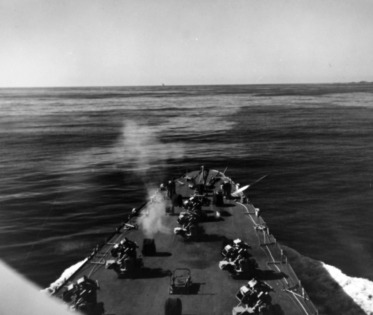 80-G-689759:  USS Carronade (IFS-1), late 1950s.  Firing rockets from deck.   Carronade was an Inshore Fire Support Ship, built to provide gunfire support to amphibious landings or operations close to shore. Official U.S. Navy Photograph, now in the collections of the National Archives.  (2017/11/01).  Photograph is extremely curved.  