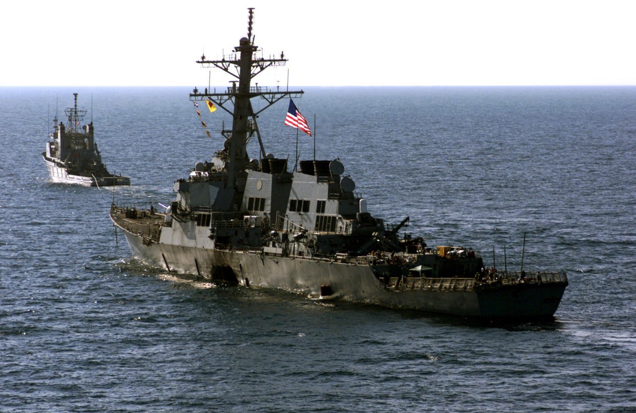 330-CFD-DN-SD-03-09092:  USS Cole (DDG-67), 2000.  Cole’s crew escort their wounded ship aboard Navy tug vessel, USNS Catawba, to a staging point in the Yemeni harbor of Aden awaiting transportation by the Norwegian-owned semi-submersible heavy lift ship MV Blue Marlin back to their homeport, during Operation Determined Response, on October 29, 2000.   Official U.S. Navy photograph, now in the collections of the U.S. National Archives.