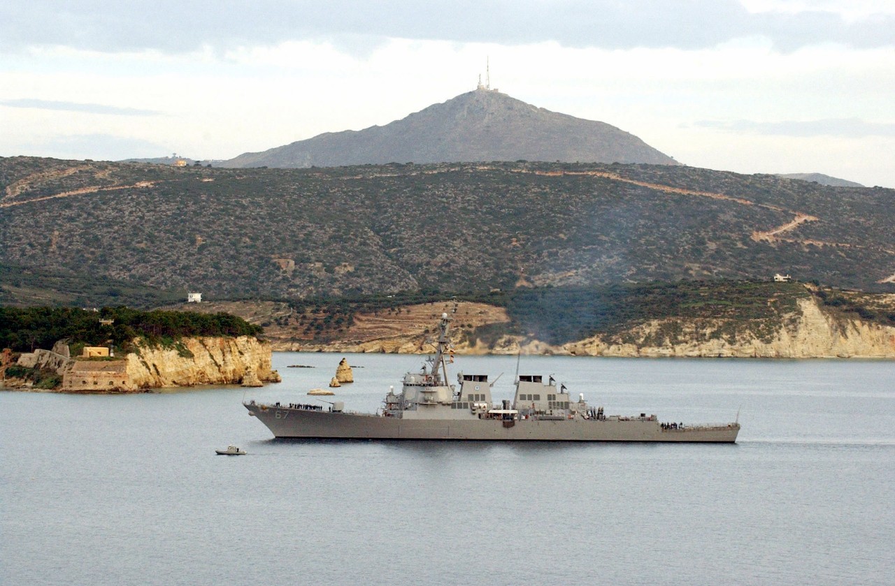 330-CFD-DN-SD-04-11118:  USS Cole (DDG-67), 2004.   The US Navy Arleigh Burke Class Guided Missile Destroyer USS Cole (DDG-67) arrives at Souda Bay for short port visit. This is the Cole’s first deployment since a terrorist attack on the ship killed 17 crewmembers and injured 39 others while refueling in the port of Aden, Yemen. Cole is part of a three ship Surface Strike Group (SSG) assigned to USS Enterprise (CVN 65) Carrier Strike Group (CSG), January 21, 2004. Official U.S. Navy photograph, now in the collections of the U.S. National Archives.
