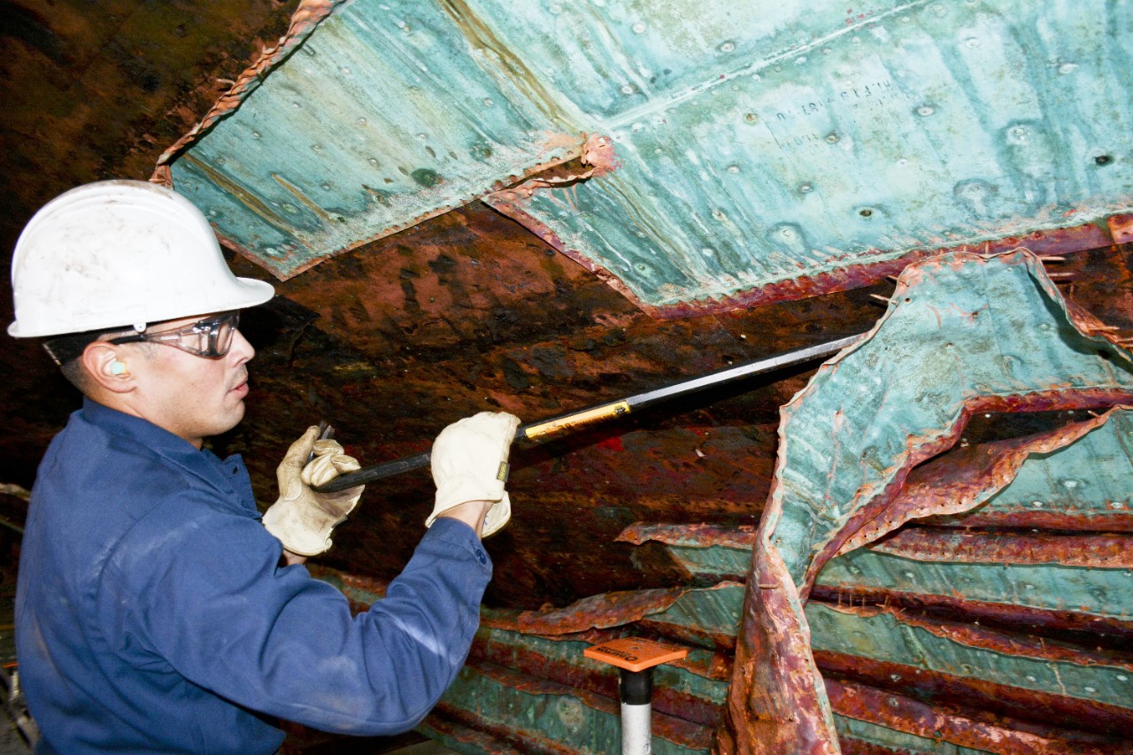 151027-N-XP344-076:  USS Constitution, 2015.  Seaman Jorge Ortiz, assigned to USS Constitution, pries a copper sheet away from the hull of Old Ironsides at Charlestown, Massachusetts, as a part of the restoration work being performed on the ship, October 27, 2015. Constitution is lined with 3,400 sheets of copper that are replaced every 15-20 years.  Photographed by MC2 Victoria Kinney.  Official U.S. Navy Photograph.   