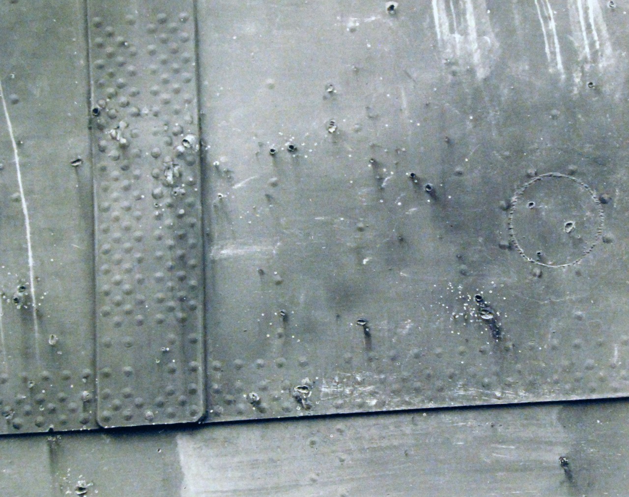 80-CF-Enterprise 1:   USS Enterprise (CV-6), 1942.   Shrapnel holes in USS Enterprise (CV 6) after Japanese bombers attack.   Three men were wounded, and one man was killed by shrapnel on the 50 cal. Battery on port quarter, 1942.   Official U.S. Navy Photograph, now in the collections of the National Archives.   (2014/9/16). 