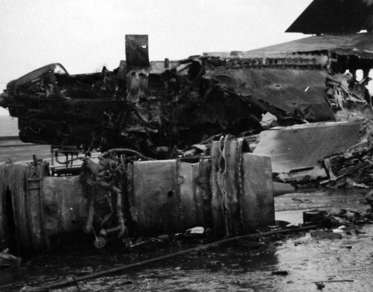 428-GX-USN-1140818:    USS Enterprise (CVAN-65), January 1969.     Pacific Ocean.  The remains of an A-7 “Corsair II” attack aircraft on the flight deck of USS Enterprise (CVN 65).  The aircraft was destroyed as the ship was conducting air operations 75 miles south of Pearl Harbor.   Photographed by PH2 Patrick J. Ryan, January 14, 1969.       Official U.S. Navy photograph, now in the collections of the National Archives.   (2016/07/26).