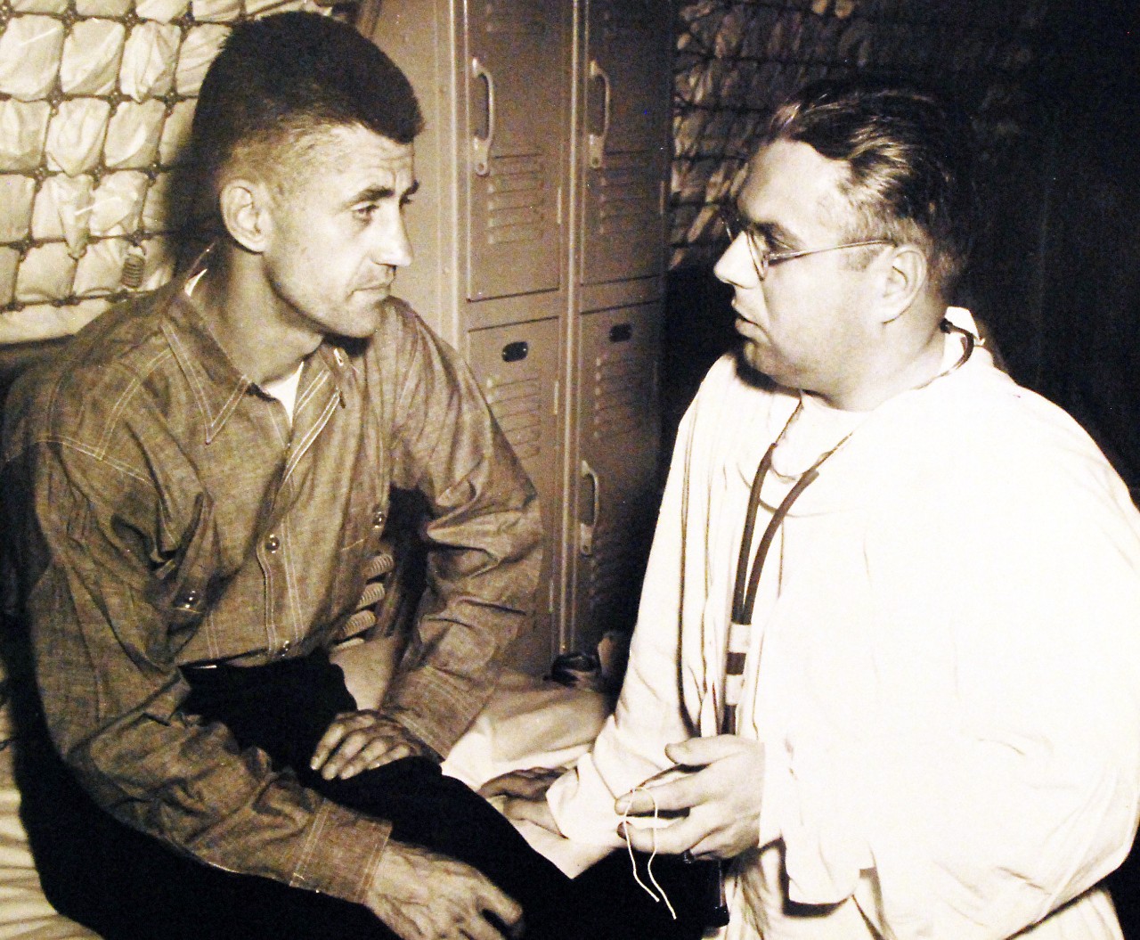 <p>80-G-490451: Commander Arthur L. Maher, senior survivor of USS Houston (CA 30) and senior prisoner at Aomori Headquarters Camp, Ohuna, talking with Lieutenant Commander W.L. Schafer, (MC), on board USS Benevolence (AH-13). Commander Maher said prisoners were subjected to illegal methods of questioning, 29 August 1945. (5/29/2014).</p>
