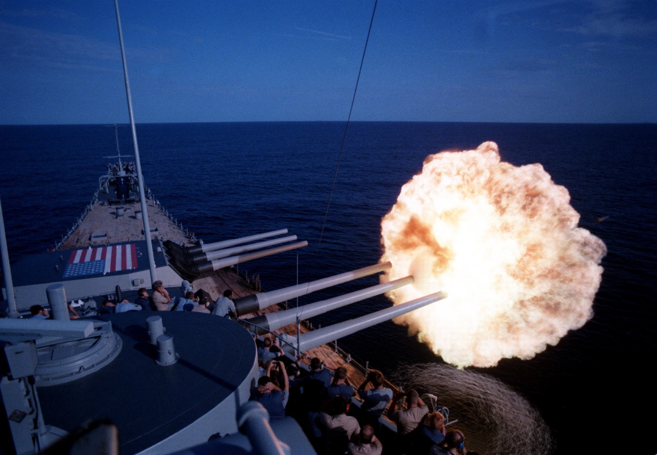 330-CFD-DN-SC-87-03282:  USS Iowa (BB-61), 1985.   A round is fired from the No. 2 Mark 7 16-inch/50 caliber gun turret during gunnery exercises aboard the battleship USS Iowa (BB 61). A projectile is visible at the edge of the burst, 8/1/1985 PH1 Jeff Hilton, USN.  (OPA-NARA II-2016/01/07).