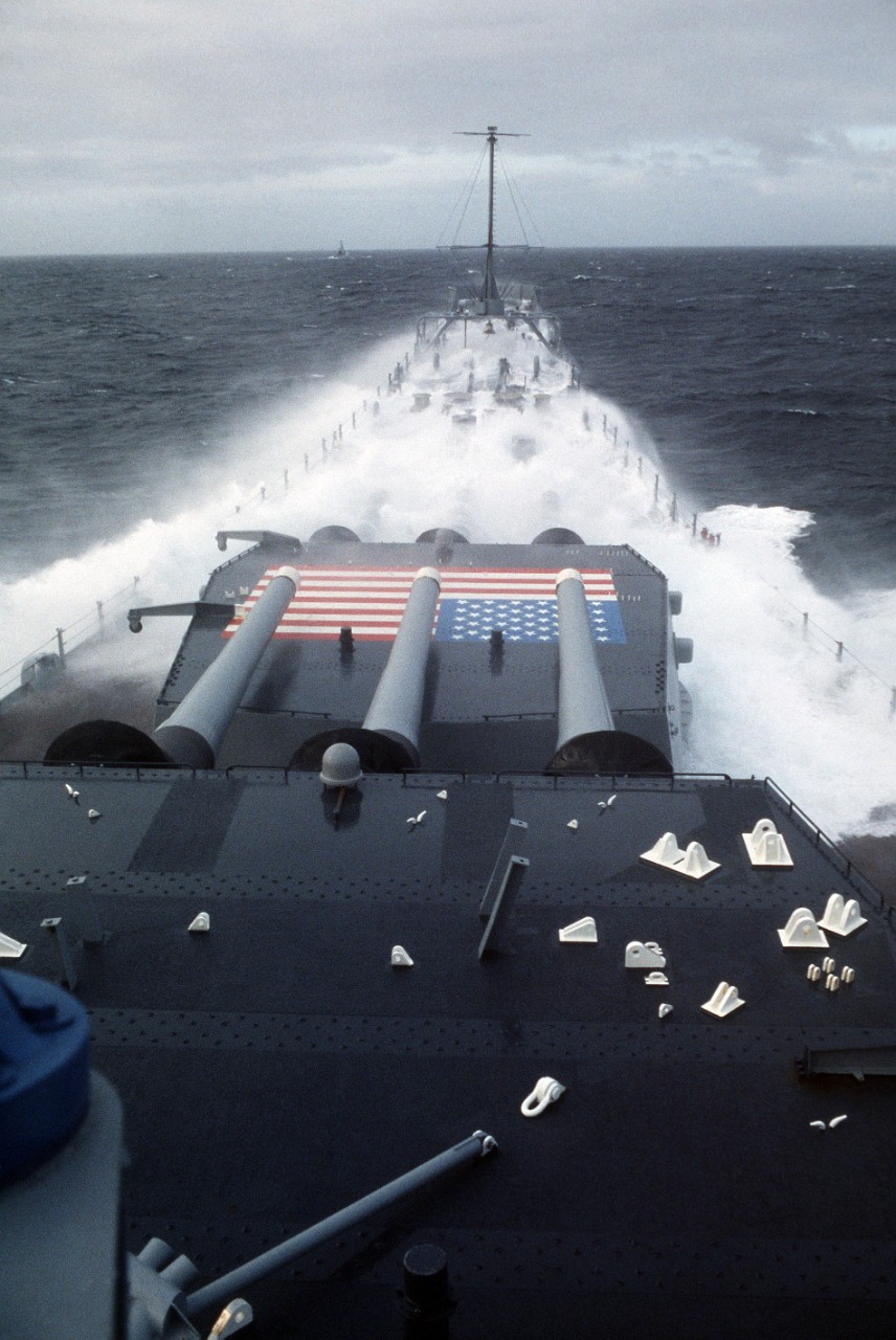 330-CFD-DN-ST-86-02556: USS Iowa (BB-61), 1985.    Waves crash on the bow of the battleship USS Iowa (BB 61) while underway in rough seas. The ship is participating in NATO Exercise Ocean Safari '85, 9/1/1985.   PH1 Jeff Hilton, USN.  (OPA-NARA II-2016/01/07).