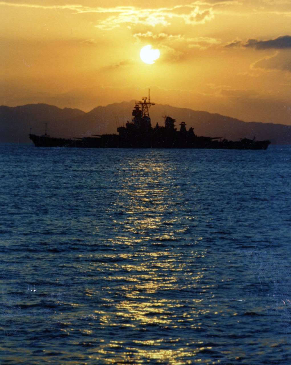 330-CFD-DN-ST-87-03463:   USS Iowa (BB 61), 1986.   USS Iowa with the sun setting behind port side of ship while moored off Puerto Caldera, Costa Rica, 1 March 1986.   Photographed by PH1 Jeff Hilton.  NHHC Photograph Collection, Navy Subject Files, Ships.