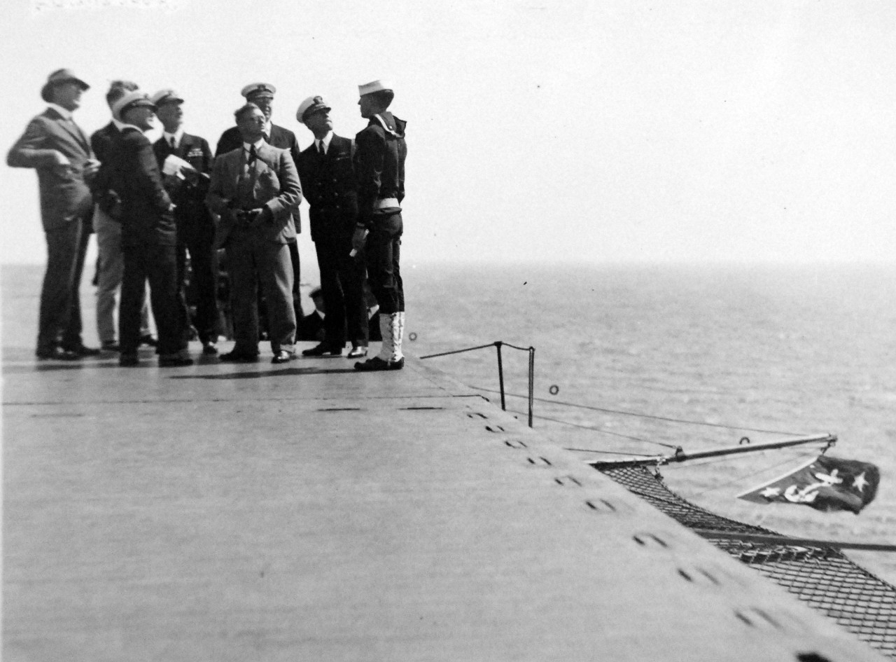 80-HAS-4B-42:   USS Langley (CV-1), 1926.    Secretrary of the Navy Curtis D. Wilbur, far left with hat, on board USS Langely (CV-1), 1 September 1926.   Note the Secretary of the Navy’s flag on the lower right.     Official U.S. Navy photograph, now in the collections of the National Archives.    (2014/8/20).   