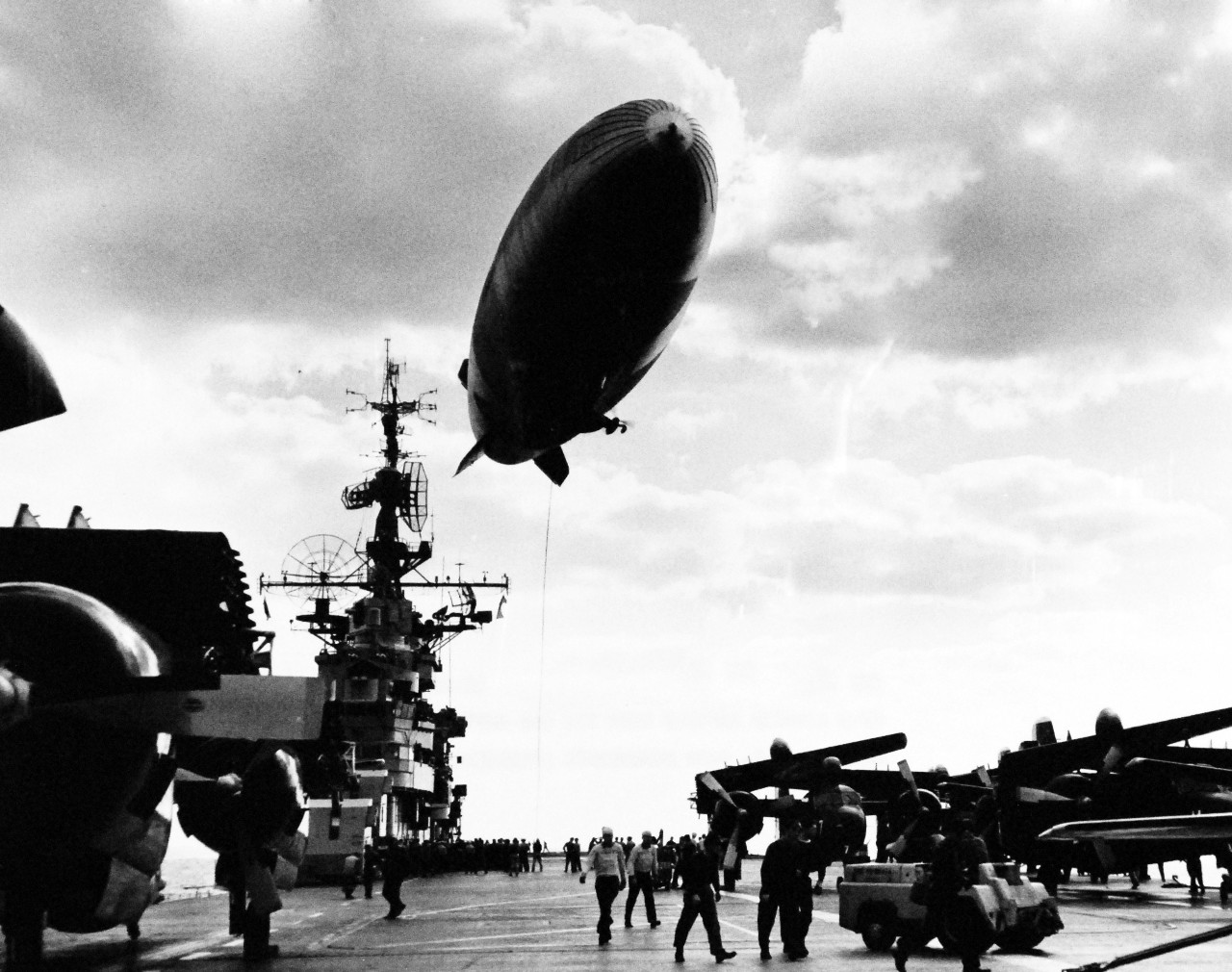 330-PS-7632 (USN 683366):  USS Leyte (CVS-32), 1955.    An airship from U.S. Naval Air Station, Lakehurst, New Jersey, refuels from USS Leyte (CV-32) during Atlantic Fleet Amphibious Operations off Cape Hatteras, November 2, 1955.   The airship was part of a Taskforce providing round-the-clock anti-submarine warfare cover for the amphibious forces.  Leyte pumped 500 gallons of fuel to the airship through a 300-foot hose while maintaining a speed of 20 knots.  Photograph released December 19, 1955.   Official U.S. Navy Photograph, now in the collections of the National Archives.    (2015/2/18).   