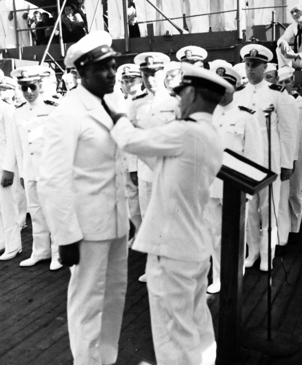 80-G-202071:   Steward 1/C Ben Edward Holt, USN, October 21, 1943.   Rear Admiral Ernest G. Small, USN, former Commanding Officer, presenting Purple Heart medals to enlisted men wounded in the Pacific on board USS Salt Lake City (CA-25).    Shown:  Steward 1/C Ben Edward Holt, USN, receives the award in recognition of wounds received onboard USS Nevada (BB-36) at Pearl Harbor, December 7, 1941.  Official U.S. Navy Photograph, now in the collections of the National Archives. 