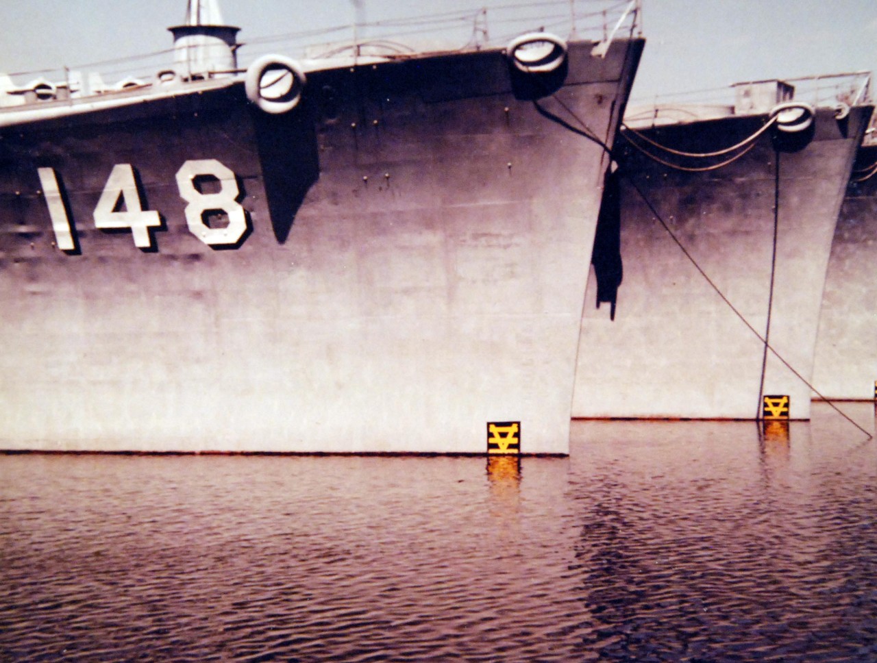 428-GX-K-128499:   Philadelphia Naval Shipyard, Pennsylvania, April 1980.   View from the water looking across starboard bows of, in turn, USS Newport News (CA-148), USS Salem (CA-139), and USS Des Moines (CA-134).  The heavy cruisers are part of the mothball fleet.     Official U.S. Navy Photograph, now in the collections of the National Archives.  (2017/10/25).  