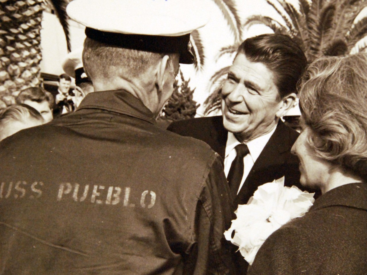 428-GX-USN-1140224:   San Diego, California, December 24, 1968.   Governor Ronald Reagan of California, (center), greets Commander Lloyd M. Bucher, Commanding Officer of USS Pueblo (AGER-2, as Mrs. Bucher looks on at right.  Commander Bucher just arrived at the U.S. Naval Air Station, Miramar, following a flight from the Republic of Korea.     Official U.S. Navy Photograph, now in the collections of the National Archives.  (2017/05/23).  Photographed from reference card.   