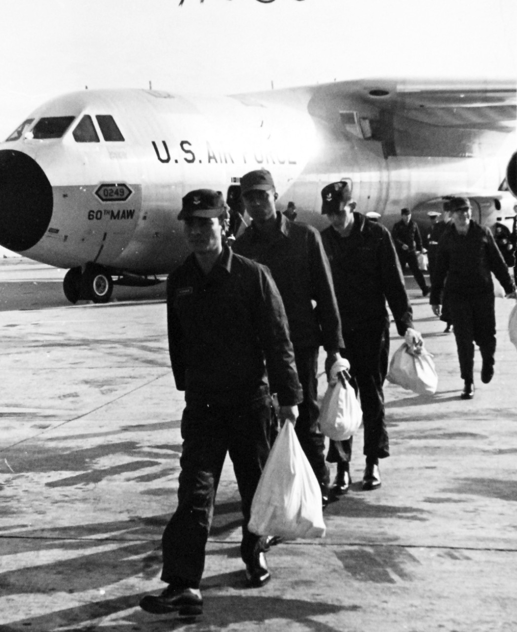 428-GX-USN-1140254:   San Diego, California, December 24, 1968.   Crewmen of USS Pueblo (AGER-2) debark from U.S. Air Force VC-137C “Stratoliner” cargo transport after a flight from the Republic of Korea to the U.S. Naval Air Station, Miramar.   Photographed by PH1 Robert A. Woods.     Official U.S. Navy Photograph, now in the collections of the National Archives.  (2017/05/23).  Photographed from reference card.   