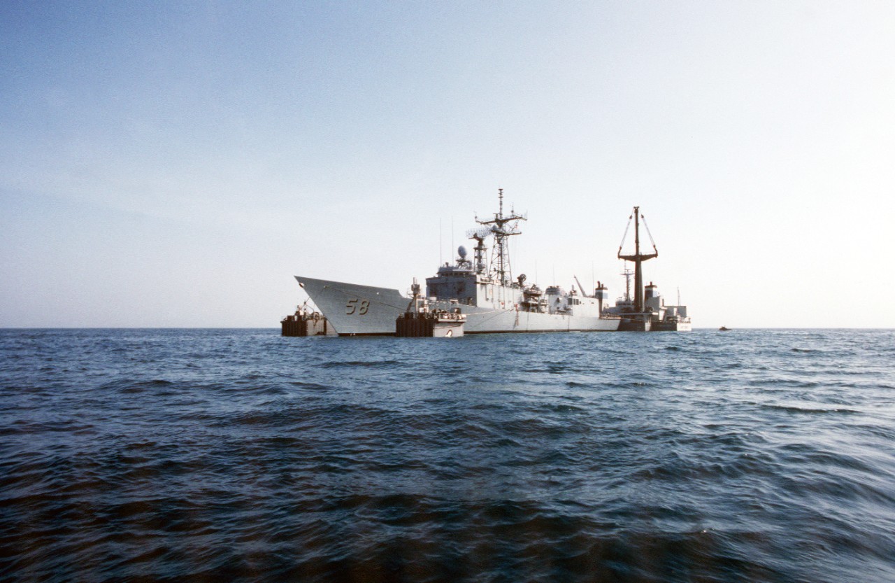 330-CFD-DN-ST-89-04398:   USS Samuel B. Roberts (FFG-58), 1988.  A port bow view of the guided missile frigate on the submerged deck of the Dutch heavy-lift ship Mighty Servant 2 in the Persian Gulf.  The Mighty Servant is transporting the frigate, which was damaged when it struck an Iranian mine on April 14, 1988, to its home port in Newport, Rhode Island, July 30, 1988.  U.S. Navy Photograph, now in the collections of the U.S. National Archives.