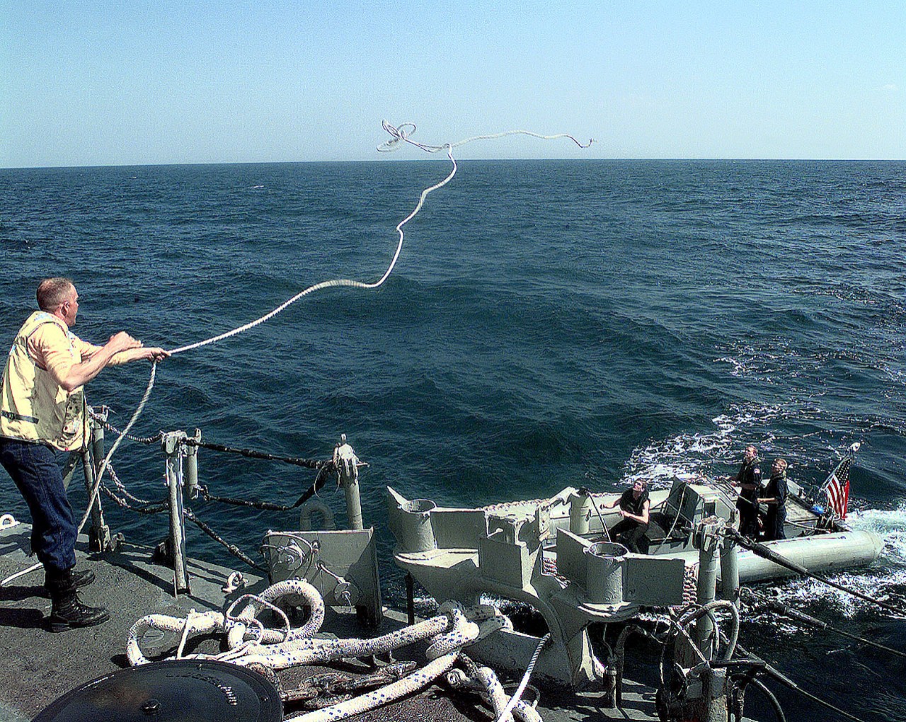 980304-N-2568S-019:   USS Samuel B. Roberts (FFG-58), 1998.   Boatswain's Mate 2nd Class Thomas Eckert throws a line out from the fantail of USS  Samuel B. Roberts (FFG-58) to his shipmates in a Rigid Hull Inflatable Boat (RHIB).  The RHIB pulled the line out to a disabled Iranian fishing boat (not shown) that needs to be towed to shore.  Roberts is patrolling the  Arabian Sea in support of the Southwest Asia (SWA) build-up, March 4, 1998.  U.S. Navy Photograph, now in the collections of the U.S. National Archives.   