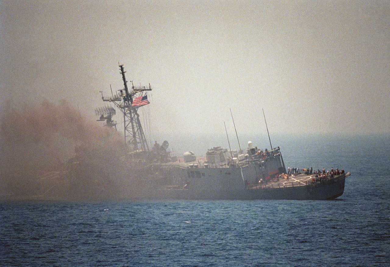 330-CFD-DN-SC-87-06413: USS Stark (FFG-31), 1987.   A port quarter view of the guided missile frigate listing to port after being struck by an Iraqi-launched Exocet missile, May 18, 1987.  U.S. Navy Photograph, now in the collections of the U.S. National Archives.  