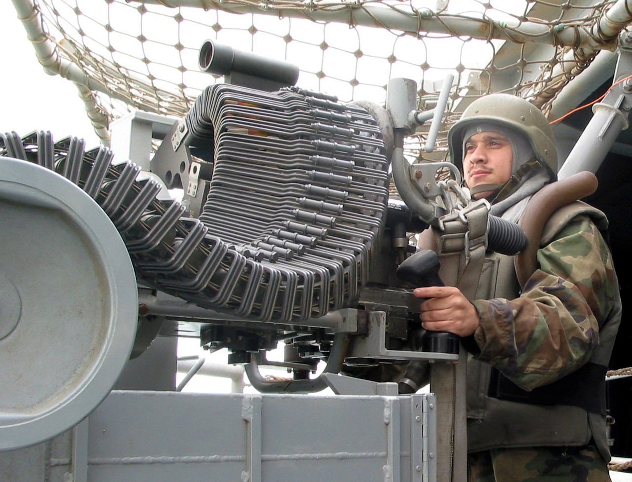 030326-N-9122P-002:   USS Tarawa (LHA-1), March 2003.    Airmen Leon Martinez III is mans an MK-38 machine gun aboard the amphibious assault ship in the Arabian Gulf, March 23, 2003.  Tarawa is deployed in support of Operation Iraqi Freedom, the multinational coalition effort to liberate the Iraqi people, eliminate weapons of mass destruction and end the regime of Saddam Hussein.  Photographed by Journalist Seaman Apprentice David Perea.  Official U.S. Navy Photograph, now in the collections of the National Archives.  